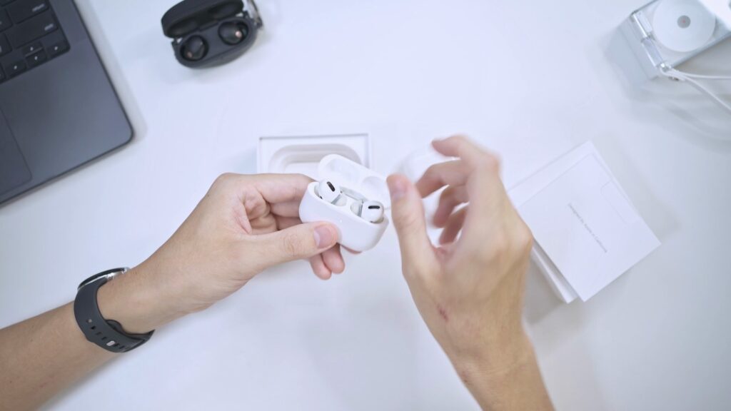 AirPods Pro 3のケースを開けて、イヤホンを取り出すところ